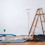 Brown wooden ladder beside painting materials