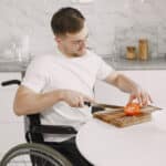 Man in Wheelchair Slicing Tomato