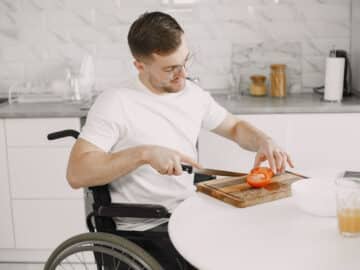 Man in Wheelchair Slicing Tomato
