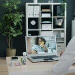 Doctor consulting patient via-video call on laptop