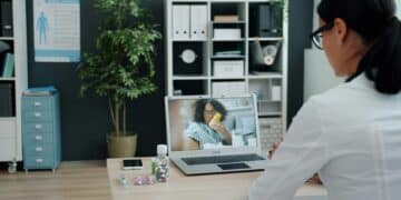 Doctor consulting patient via-video call on laptop