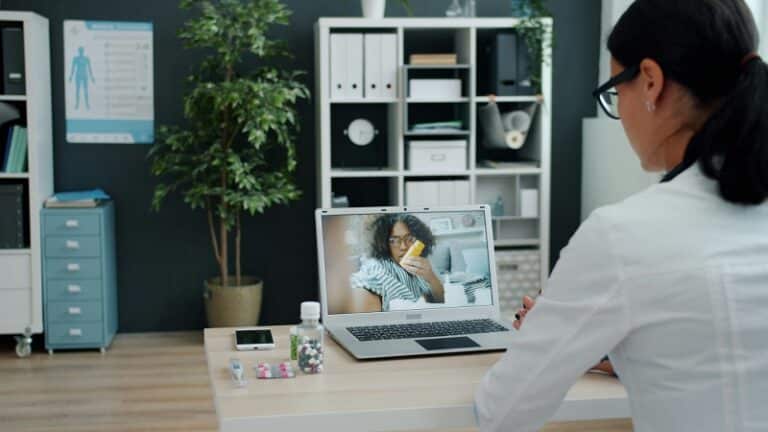 Doctor consulting patient via-video call on laptop