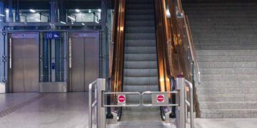 A modern indoor escalator and elevators in a public space, showcasing urban architecture.