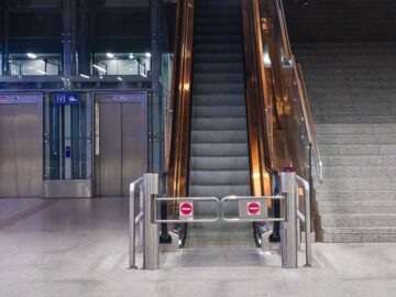 A modern indoor escalator and elevators in a public space, showcasing urban architecture.