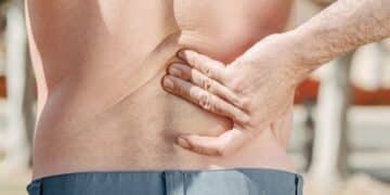 Man holding his lower back in pain, possibly indicating discomfort or injury